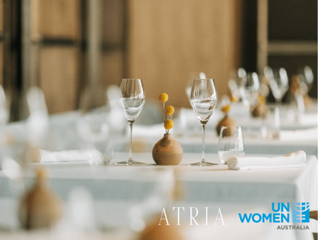 Atria Restaurant dining table with wine glasses with branding logo of Atria and UN Women Australia
